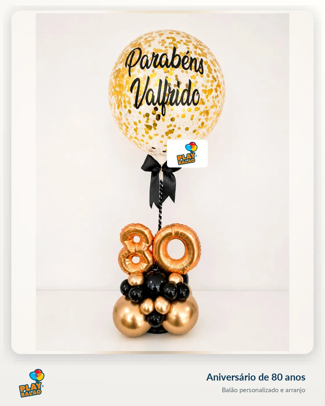 Balão bubble personalizado 'Parabéns' sobre arranjo de 80 anos em preto e dourado